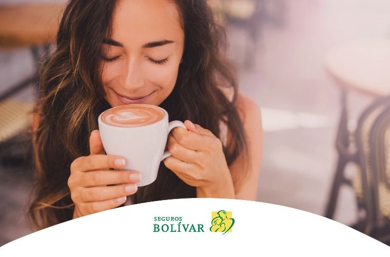 Mujer disfrutando una taza de café, representando sus beneficios para la piel.