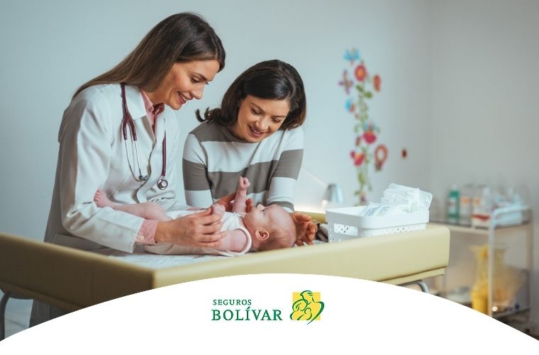 Médica pediatra examinando a un bebé junto a su madre, ilustrando qué es la pediatría.