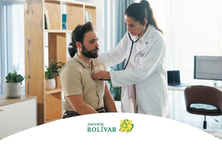 Una médica ausculta el pecho de un paciente sentado en un consultorio