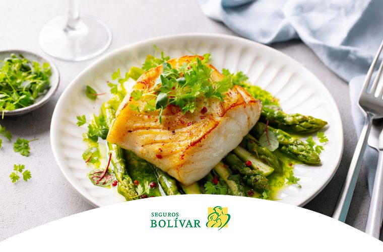 Filete de pescado a la plancha servido sobre una cama de espárragos verdes con hierbas frescas, resaltando una alimentación saludable.