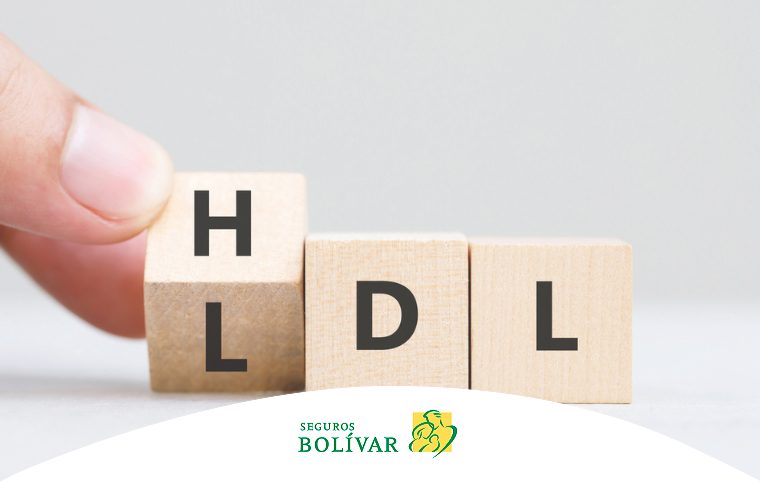 Mano girando cubos de madera para cambiar la sigla de LDL a HDL, representando el control del colesterol.